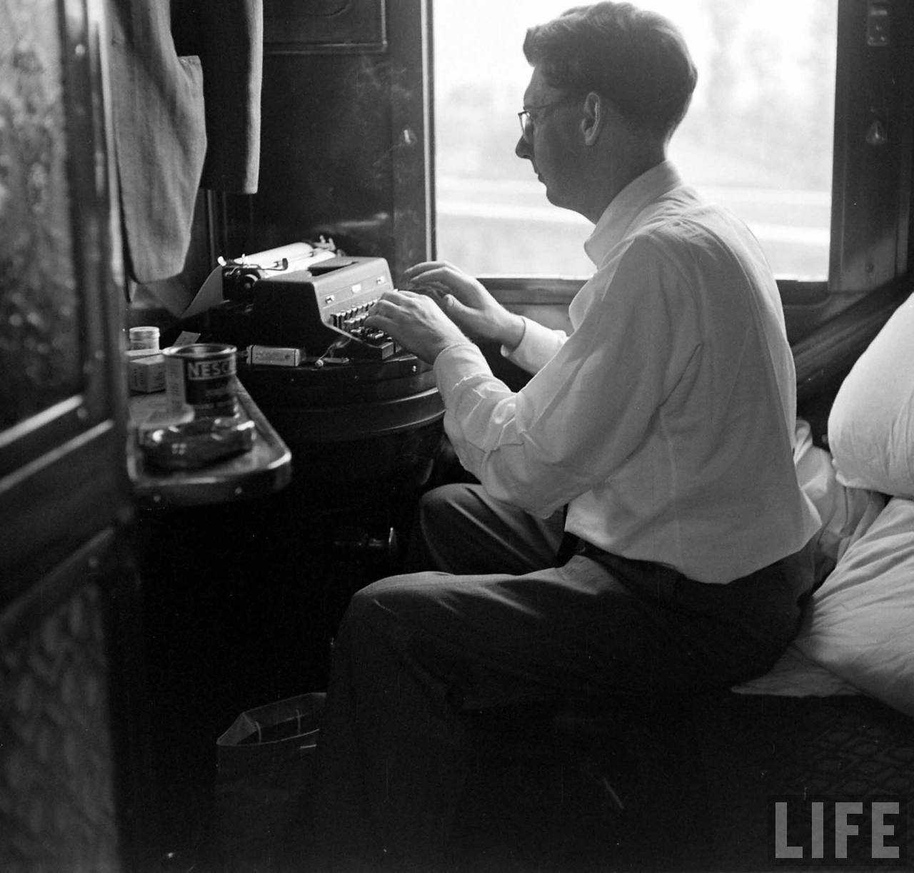 Roy Rowan met schrijfmachine in trein | Foto: Jack Birns, 1950